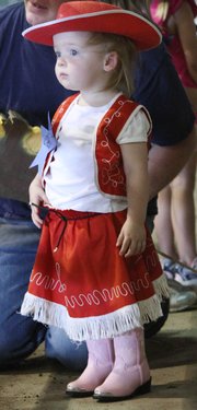 Dressed in her cowgirl outfit, Cleo Trigg, 2, Lawrence, waited for the stick-horse competition on Sunday.