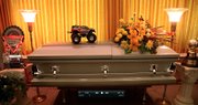 A replica of Iron Outlaw, a monster truck driven by Nick Owens, sits on his casket during services for the Tonganoxie man Wednesday. Owens, 30, drowned Saturday at Lone Star Lake in Douglas County.
