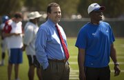 Kansas Athletic Director Sheahon Zenger hangs out with head football coach Turner Gill on the sidelines of practice on Tuesday, Aug. 16, 2011.