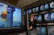 A Sears saleswomen, in Lawrence, watches the tragic events of Sept. 11, 2001, unfold on TV sets surrounding her. Documenting the effects of the event a thousand miles away presented a visual challenge in connecting those of us living in Lawrence with the tragedy in New York.
