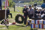 Leavenworth County Commissioner Clyde Graeber and Leavenworth County Sheriff Dave Zoellner pay their respects after participating in the laying of wreaths during Sunday’s 9/11 remembrance ceremony at Leavenworth. Seated at left is U.S. Sen. Jerry Moran, R-Kan.