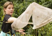 Eleven-year-old Savannah Beckerman, Kansas City, Mo., concentrates as she nets a monarch butterfly Sunday at the Prairie Park Nature Center, 2730 Harper St.