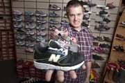 Halston Rucker of Brown's Shoe Fit Company, 829 Mass., shows off a selection of kids' shoe styles. Rucker says that durability and fit vary greatly and it's best to get your child's shoes fitted by a professional.