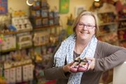 Kris Bailey, owner of Blue Dandelion, 841 Mass., is pictured with a pair of little girls shoes at her store. Bailey says that, while tempting, parents should avoid buying roomy shoes for new walkers. The extra room, while good for growing, can make it hard for new walkers to move properly.