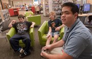 Philip Fukuto, foreground right, youth services assistant at Lawrence Public Library, 707 Vt., and a skilled video game player, provides lessons on the game “Super Smash Bros. Brawl,” on Oct. 5. From left are Alejandro Esparza, 12, and Nathan Fletchall, 12.