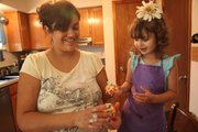 Aniela Kiekel and her daughter, Shasta, 3, enjoy putting together a sticky treat — popcorn balls. Kiekel says she measures out the ingredients and lets Shasta add them in. Popcorn balls are a mixture of popcorn, marshmallows, butter and food coloring.