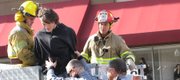 A protester affiliated with the Occupy Lawrence group is taken from a crane into police custody at Ninth and Massachusetts streets on Nov. 5, 2011. The man, who has not yet been identified but whom protesters say is Shaun Maupin, was arrested after spending nearly an hour shouting from the roof of Weaver's in a mask.