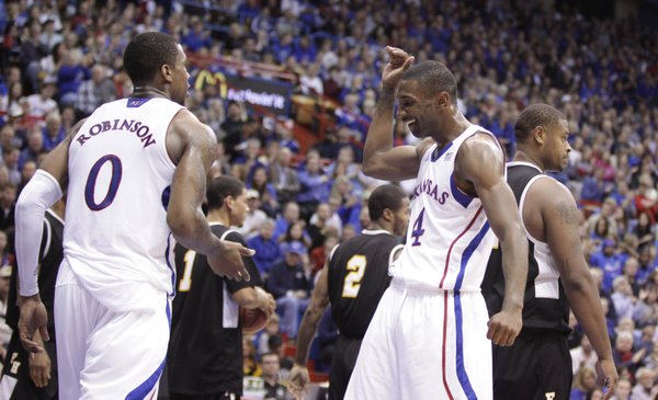Teammates Justin Wesley (4) and Thomas Robinson slap hands after a Robinson converted a bucket and a foul against Fort Hays State during the first half on Tuesday, Nov. 8, 2011 at Allen Fieldhouse.