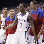 Kansas guard Naadir Tharpe pumps his fist after converting a bucket after being fouled by a Fort Hays State defender during the second half on Tuesday, Nov. 8, 2011 at Allen Fieldhouse. Pictured are teammates Kevin Young, left, Niko Roberts and Merv Lindsay.