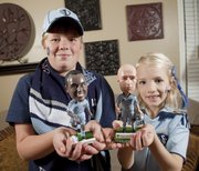 Ben Urban, 10, and his sister Grace, 8, along with their parents, are big fans of Sporting KC soccer team. The two hold bobble-head dolls of two of their favorite KC players.