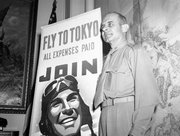 In this May 19, 1942 file photo, U.S. Army Air Corps Brig. Gen. Jimmy Doolittle poses with a new Air Corps poster in Washington. A month before, on April 18, Doolittle led 16 North American B-25s from the flight deck of the USS Hornet for the Army's first air raid on Tokyo. Coming just four months after the Imperial Japanese Navy savaged the U.S. Pacific Fleet at Pearl Harbor, the Doolittle raid on Japan's home did little damage, but lifted the spirits of Americans and electrified a world at war. (AP Photo, File)