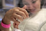 14-week-old Melinda Star Guido holds her mother's little finger while lying in an incubator at the Los Angeles County-USC Medical Center in Los Angeles, Wednesday, Dec. 14, 2011. At birth, Melinda Star Guido tipped the scales at only 9 1/2 ounces, a tad less than the weight of two iPhone 4S. Most babies her size don’t survive, but doctors are preparing to send her home as soon as the end of the month. Melinda is believed to be the second smallest baby to survive in the United States and the third smallest in the world.