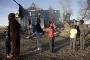In this file photo, Camay Guillory, second from left, and her children look at what’s left of their rural Douglas County home after a fire destroyed the house Dec. 29, 2011. Members of the Guillory family all escaped safely from the fire, something they had practiced in their home.
