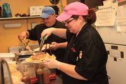 Jeff and Valery Frye, Lawrence, work together in their catering and barbecue sauce business, Mr. Bacon, at Conroy’s Pub, 3115 W. Sixth St., on a recent Friday night.