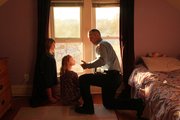 Prairie Mulligan, 4, and her sister Arbor, 6, listen to Lt. Aaron Flory of Lawrence-Douglas County Fire Medical talk about fire escape routes from their bedrooms, and what to do if they have to leave by a window.
