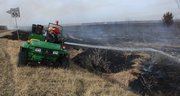 Grass fires were reported throughout Douglas County Thursday. Some were controlled burns, getting grass ready for the spring rains. Lawrence parks department employee Lenny Irey sprays some water on a fire just south of Eagle Bend Golf Course.
