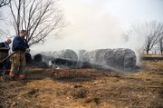 Palmyra Township Fire Department firefighters douse hay bales Thursday, Feb. 2, 2012, at 2164 N. 400 Rd. The fire started after a renter at the property started to burn brush.