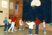Boys and Girls Club members play basketball in one of the program's school sites. Under the direction of executive director Janet Bremby, the organization began expanding into school sites in the early 2000s.