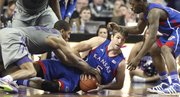 Kansas center Jeff Withey gets on the floor for a loose ball with Kansas State forward Rodney McGruder during the second half on Monday, Feb. 13, 2012 at Bramlage Coliseum. At right is KU guard Elijah Johnson.