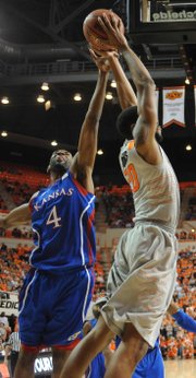 Kansas sophomore Justin Wesley gets his hand on the ball for a block on Oklahoma State's Markel Brown on Monday night.