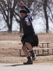 Kilt-clad Billy Williams winds up as he throws a bowl during an Irish road bowling tournament on Sunday at Clinton Lake State Park. The goal of Irish road bowling is to roll a 28-ounce iron cannonball around the course. The winner is determined by whoever makes it around the course in the least amount of throws.