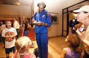 Kansas forward Thomas Robinson smiles as he stops to sign autographs for a cluster of young fans upon the team's arrival at the Embassy Suites in downtown Omaha.