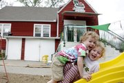 Rhys Fife, left, and Cecilia Divine-Devictor play outside the Lawrence Community Nursery School, the second-oldest nursery school cooperative in the country and one of Lawrence’s many co-ops.
