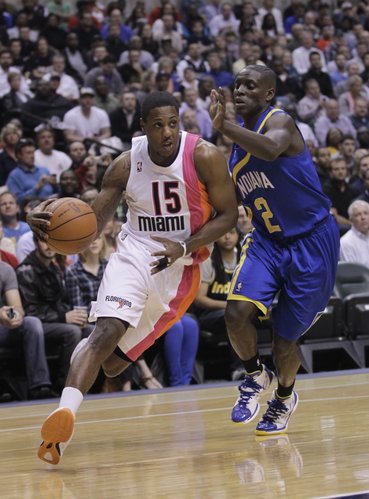 Miami Heat guard Mario Chalmers, let, drives on Indiana Pacers guard Darren Collison in the first half of an NBA basketball game in Indianapolis, Monday, March 26, 2012.