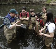 Chris Bowser, left, of the New York State Department of Environmental Conservation checks a net for American eels with Kingston High School students on the Black Creek in West Park, N.Y., in this April 18, 2011, file photo. An academic analysis of surveys spanning more than 40 years has found that today’s young Americans are less interested in the environment and in conserving resources — and often less civic-minded overall — than their elders were when they were young.