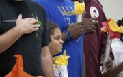 Nine-year-old Aris Grady listens to the national anthem while holding her Olympic torch during the Quail Run Girl Scouts' annual father-daughter event Sunday.