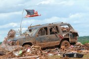 A tattered American flag flies over a vehicle where two young girls ages 5 and 7 were found after a severe thunderstorm spawned a massive tornado at Hideaway Mobile Home Villa in Woodward, Oklahoma shortly after midnight Sunday, April 15, 2012. The girls, Faith and Kelley Hobbie, ages 5 and 7, and their father, Frank Hobbie, were three of the five fatalities in the Northwest Oklahoma destruction.