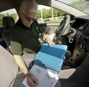 Michael Van Pelt, a Lawrence Memorial Hospital lab courier, records deliveries in his log book on his route, Wednesday, May 2, 2012. Van Pelt is grateful for the financial and emotional support he received from his colleagues while battling cancer last year. He received $700 from the annual LMH Employee Campaign in addition to gift certificates for a holiday meal and presents for his family.
