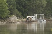 A dredging operation sits east of downtown Lawrence along the Kansas River. Environmentalists say proposals to expand dredging of the river would degrade the river bed and bank, as well as stir up pollutants that have settled at the bottom of the river.