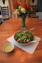 Ivy Travis' mother-in-law's spinach salad uses fresh spinach, sweet peppers, mushrooms, bacon, and finishing off with a mustard vinegar based dressing.