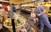 Lawrence resident Liz Black lays some potatoes in her cart as she shops with her 2-year-old daughter Arie on Tuesday, May 22, 2012, at The Merc, 901 Iowa.