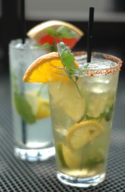 Spiked Lemonade (left) or Spiked Lemonade Shandy (just add beer) can be made with any combination of fruit and herbs you like. PIctured are Spiked Lemonade with citrus fruit and mint and Spiked Lemonade Shandy with citrus fruit, cilantro and Tajin chili-lime seasoning on the rim, created by bartender Lindsay White at Esquina, 801 Mass.