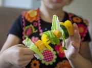 Audrey Montgomery, 4, creates a Salad on a Stick by stacking cheese, peppers, lettuce and zucchini and other vegetables on a wooden skewer.