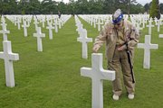 U.S. WW II veteran Clarence Mac Evans, 87, from West Virginia, who landed in Normandy on June 6, 1944, with the 29th infantery division, puts a coin on the tomb of fellow Franck Nuzzo, from the 29th division who died on June 6, 1944, at the Colleville American military cemetery.