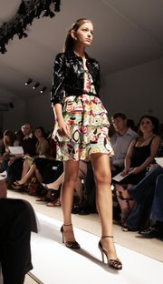 A model wears a lacquered cropped jacket over a modernist print top and skirt at Cynthia Steffe's spring 2006 collection during Fashion Week in New York, Monday Sept. 12, 2005. Wear a cropped jacket or blazer to a summer wedding if you don't want to bare your arms.