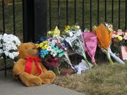 Friends and neighbors of Ron and Rebecca Bramlage and their four children leave flowers and other items at the fence of their home to honor them after their deaths, Thursday, June 7, 2012, in Junction City, Kan. The family died in a Florida plane crash.