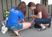 Bella Oman, left, and her mother, Sabine Omann, right, lay flowers outside the home of the Ron and Rebecca Bramlage and their four children, Thursday, June 7, 2012, in Junction City, Kan. The family died when their small aircraft crashed in central Florida, and Bella Omann was a middle school classmate of two of the Bramlage children.