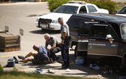 Police handcuff a man in the parking lot of Wal-Mart, Sixth and Congressional, on Wednesday, June 13, 2012.