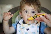 Camden Hobbs, 18 months, gets wide-eyed as he takes another bite of pureed squash during lunch on Thursday in his Lawrence home.