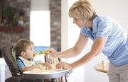 Christina Hobbs coaxes in another bite for her son Camden, 18 months, by way of a dump truck spoon on Thursday in their Lawrence home. Hobbs makes all of Camden’s food.