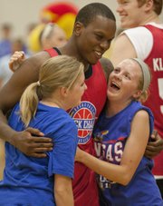 Sarah, right, and Mary Buckels are surprised when Russell Robinson walks up behind them before the start of the Rock Chalk Roundball Classic held Thursday, June 14, 2012, at Free State High.