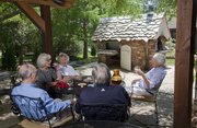 Marilyn Clark, right, had an outdoor oven constructed by area stonemason Keith Middlemas designed like a small cottage. It includes a wood-fired oven and a built-in slide out grill. Clark is joined by friends on her patio from left, Mike and Kitty Johnson and Marianne and John Wilkinson.