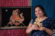 Amrutha Ravikumar, owner of Cosmos Indian Store, holds a statue of the Goddess Dhurga, the goddess of power, which is one of the items available in the new store at 734 Mass.