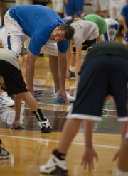Former KU player Mark Randall, left, leads a warm-up exercise during the Cole Aldrich basketball camp Monday, July 9, 2012, at Olathe Northwest High School.