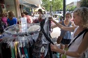 Suzie Craig, right, Lawrence, and her daughter Anna, a junior at Free State high school, check out a rack of clothes at Britches during the annual Downtown Lawrence Sidewalk Sale, Thursday, July 19, 2012.