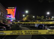 People gather outside the Century 16 movie theatre in Aurora, Colo., at the scene of a mass shooting early Friday morning, July 20, 2012. Police Chief Dan Oates says 14 people are dead following the shooting at the suburban Denver movie theater. He says 50 others were injured when gunfire erupted early Friday at the Aurora theater. Oates says a gunman appeared at the front of one of the Century 16 theaters.